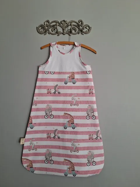 Summer Baby Sleep Sack in the Pink Stripes print, hanging on a wall hook